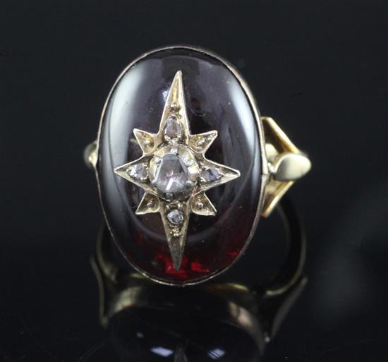 A Victorian gold and cabochon garnet ring, with central rose cut diamond set star motif, size L.